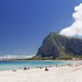 Spiaggia di San Vito Lo Capo, un vero paradiso di **Palermo mare senza auto**. Acque cristalline, sabbia bianca e la maestosa montagna di Monte Monaco.