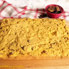 Pincia veneziana, dolce tipico natalizio, con uvetta e fichi secchi, su tagliere di legno.