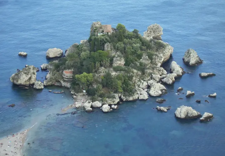 Isola Bella, una perla tra le spiagge della Sicilia orientale, con scogli e vegetazione lussureggiante.