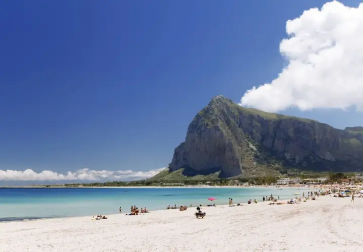 Spiaggia di San Vito Lo Capo, un vero paradiso di **Palermo mare senza auto**. Acque cristalline, sabbia bianca e la maestosa montagna di Monte Monaco.