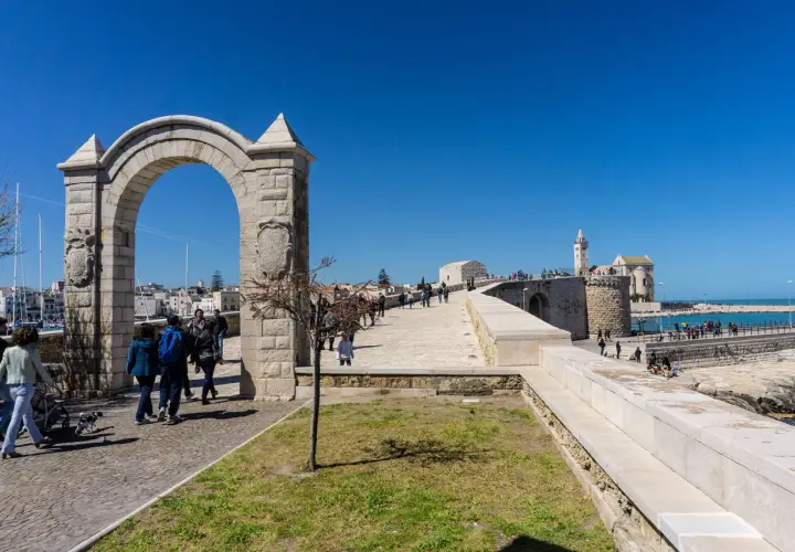 Arco monumentale e passeggiata sul lungomare, con la cattedrale in lontananza. Ecco cosa vedere a Trani.