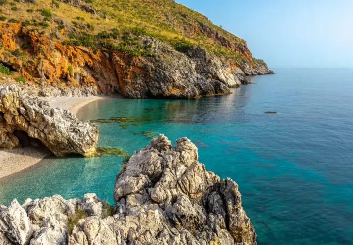 Una caletta nascosta con acque cristalline e rocce imponenti, un gioiello tra le **best beaches in Sicily**.