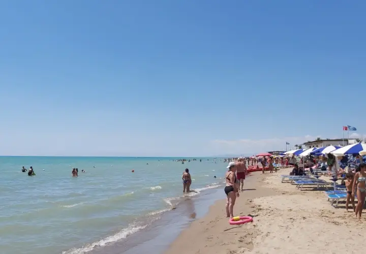 Giornata di sole al Metaponto Lido. Gente in acqua e sotto gli ombrelloni, bagnanti che si godono la spiaggia.