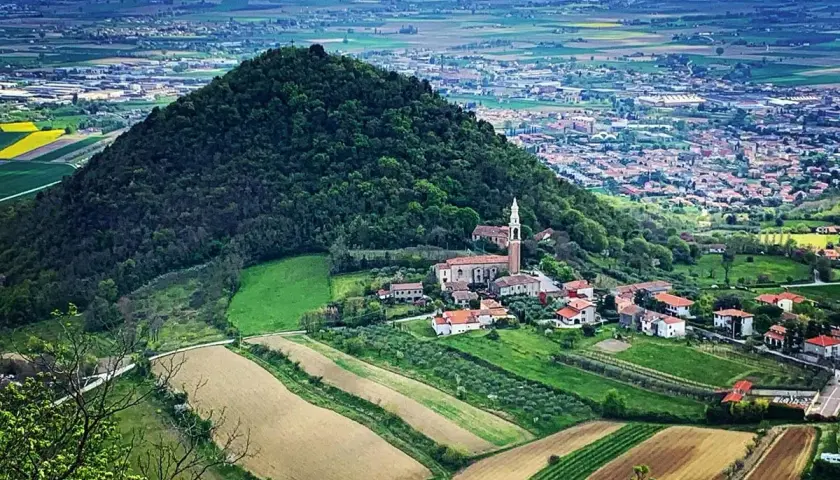 Panoramica dei Colli Euganei con un borgo e campi coltivati. Ideale per scoprire i ristoranti dei Colli Euganei.