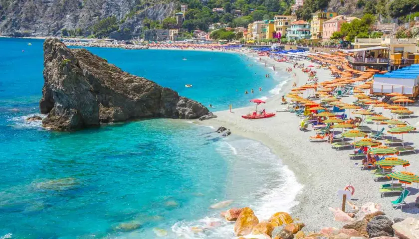 La monterosso spiaggia libera è affollata di ombrelloni colorati e bagnanti che si godono il sole e il mare cristallino.