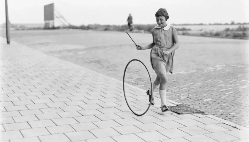 Bambina gioca con un cerchio, un gioco che ricorda i giochi antichi siciliani.
