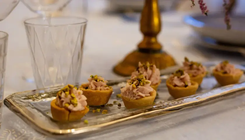 Tartellette rosa con pistacchi, pronte per un aperitivo a Verona.