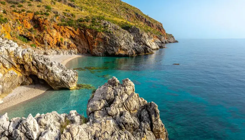 Una caletta nascosta con acque cristalline e rocce imponenti, un gioiello tra le **best beaches in Sicily**.