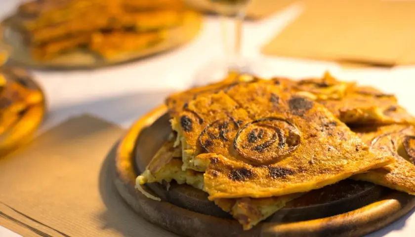 Farinata dorata, un classico per sapere cosa mangiare a Pisa. Croccante fuori, morbida dentro, con cipolle caramellate.
