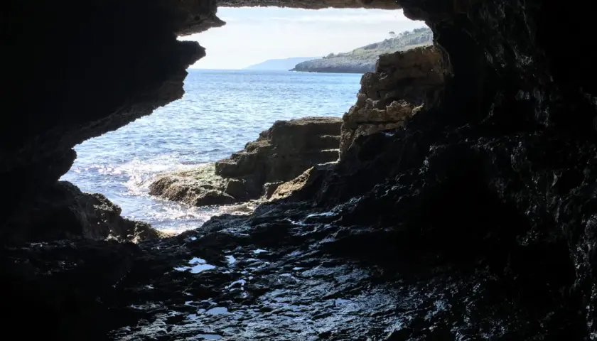 Vista dall'interno di una grotta sul mare cristallino e la costa rocciosa. La spiaggia della grotta verde è un luogo magico.