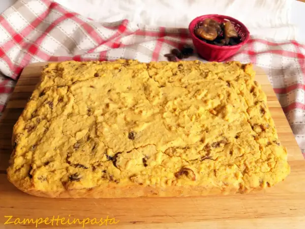 Pincia veneziana, dolce tipico natalizio, con uvetta e fichi secchi, su tagliere di legno.